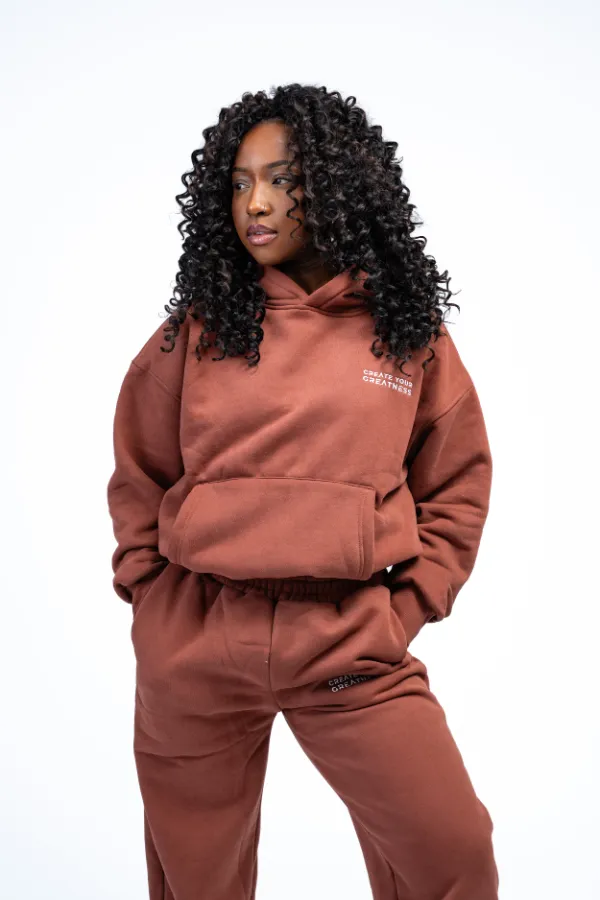 Model wearing the Signature Boxy Hoodie in brown with matching sweatpants